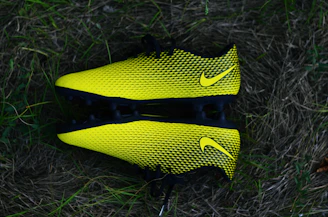 Shiny black and gold shin guards arranged neatly on a white background.
