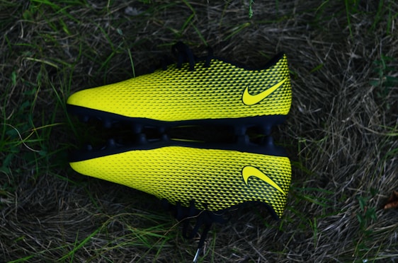 Close-up of a sleek soccer cleat gripping artificial turf under bright stadium lights.
