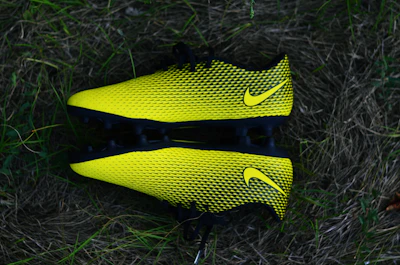 A vibrant display of colorful soccer cleats lined up on a grassy field.