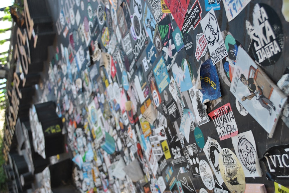 a wall covered in lots of stickers and signs