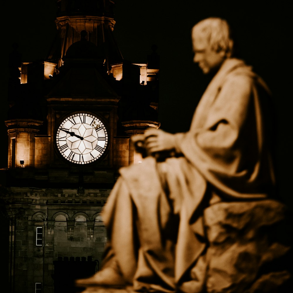 grey analog clock near statue