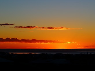 A vibrant sunset over a scenic landscape, reflecting the colors of yellow, blue, orange, and green.