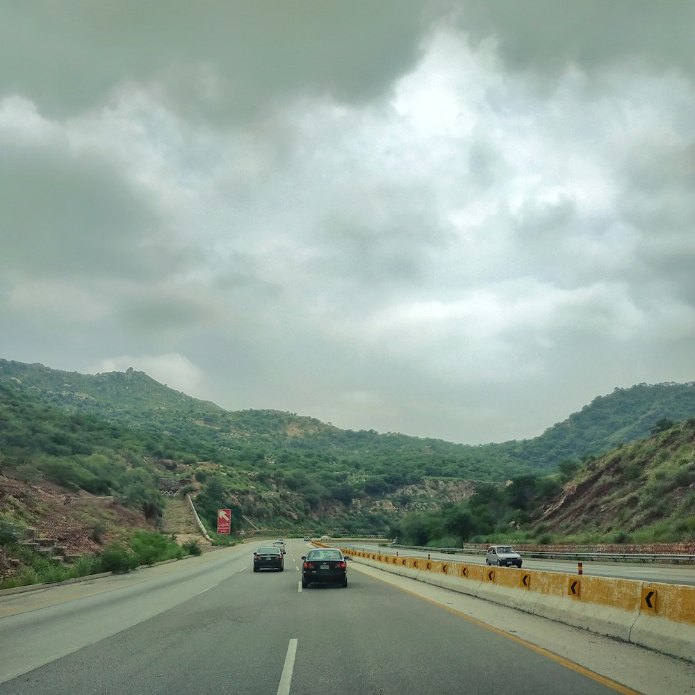 vehicles passing-by concrete road under dramatic sky