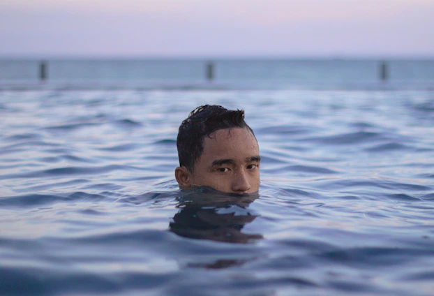 un homme nageant dans une étendue d'eau