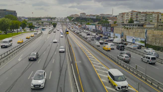 A busy highway with multiple Uber cars featuring colorful branded wraps moving smoothly during rush hour.