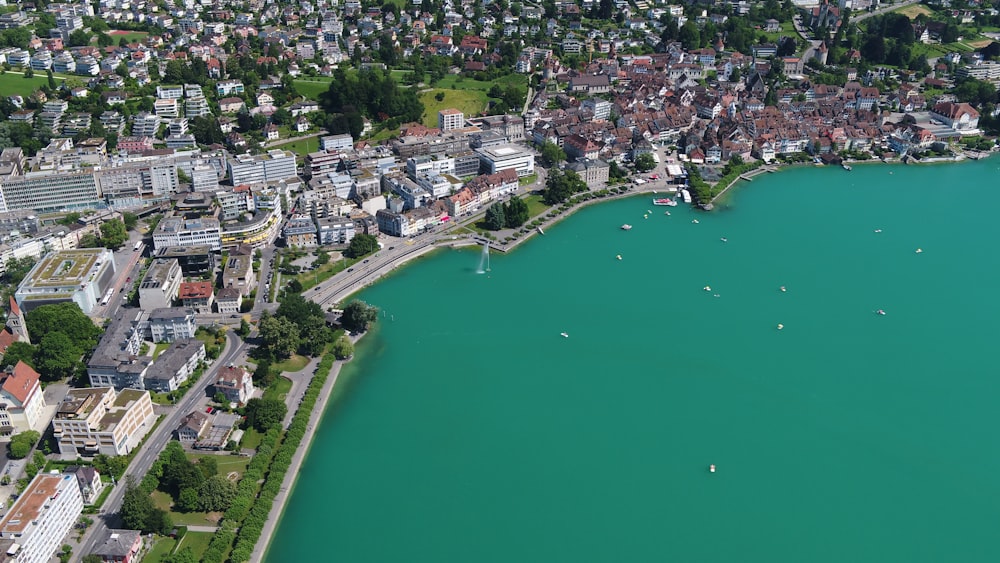 an aerial view of a city next to a body of water