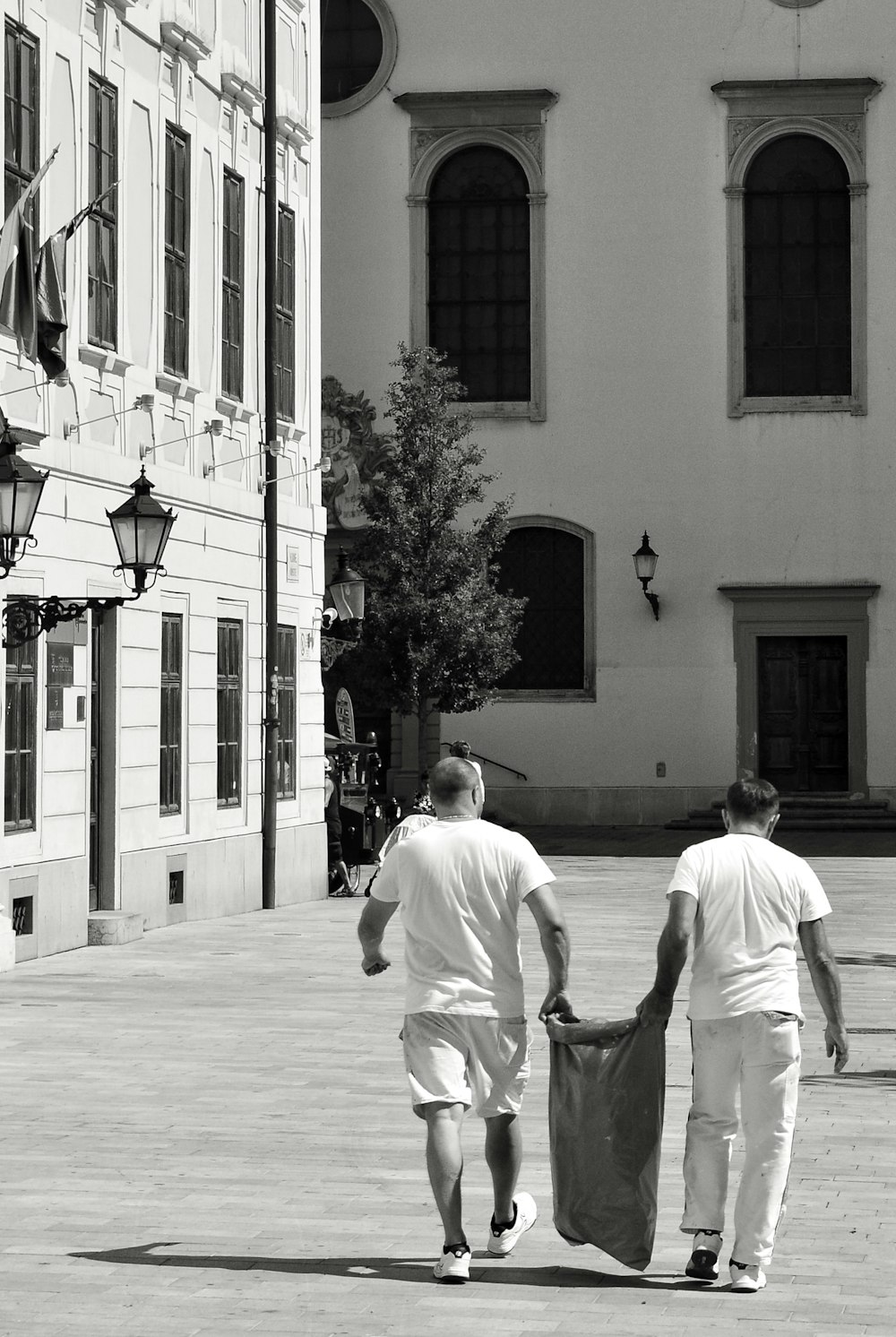 two men carrying sack