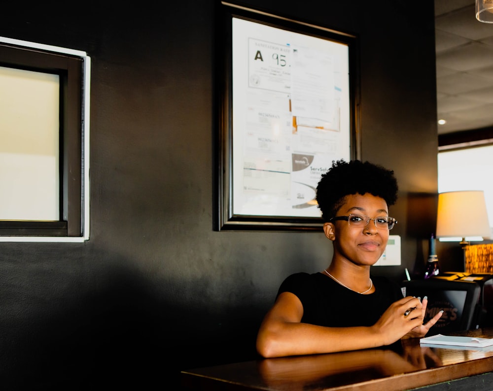 smiling woman sitting near wall with mounted photo