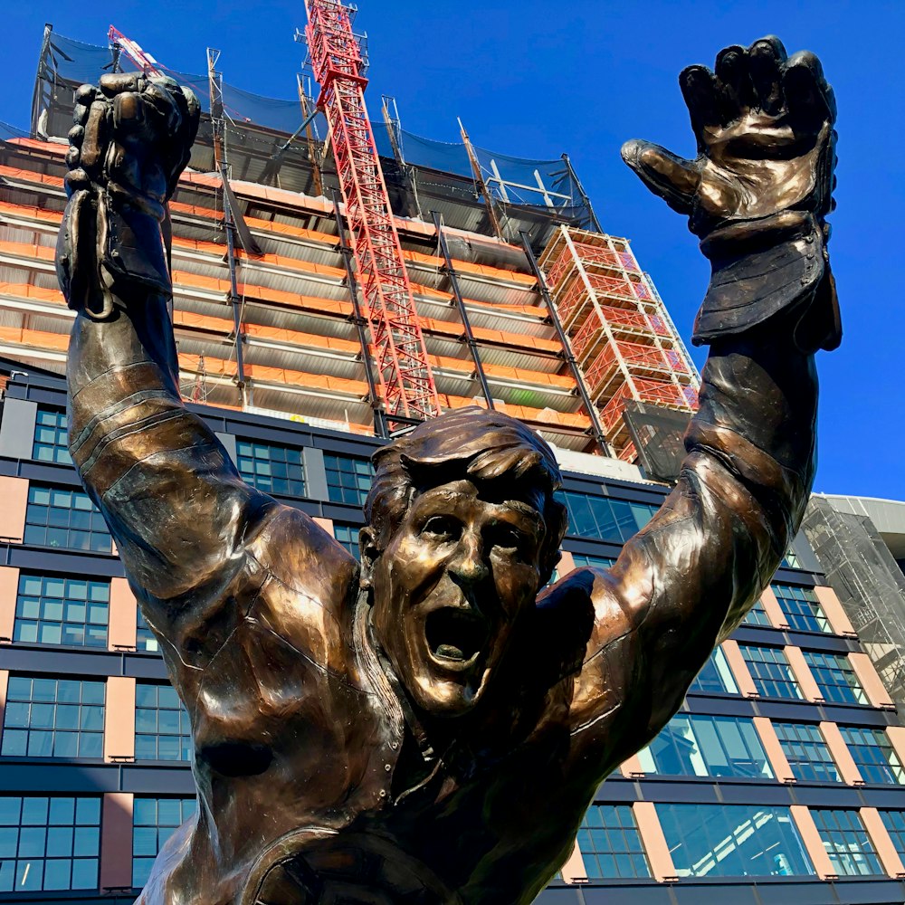 man's statue near constructed building