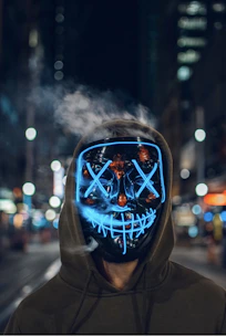 Close-up of a glowing LED mask with intricate cybernetic designs under purple lighting.