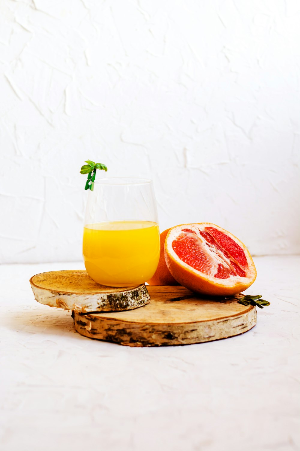 glass of orange drink and sliced grapefruit
