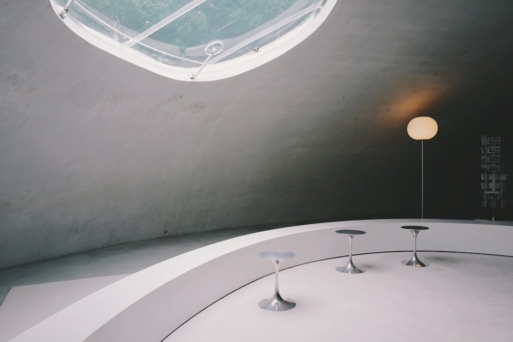 a circular room with a skylight and two tables