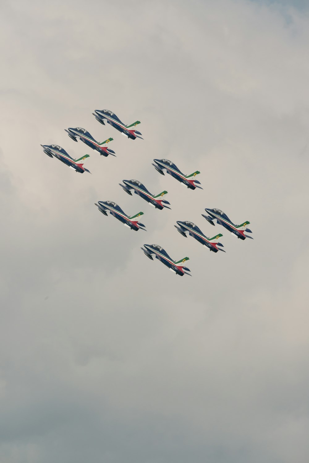 a formation of fighter jets flying through a cloudy sky