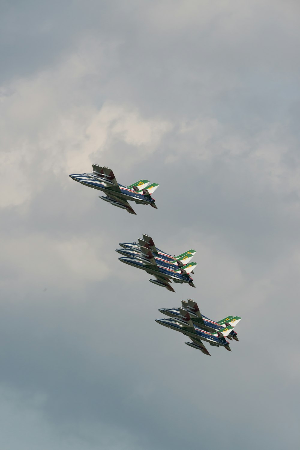 a group of fighter jets flying through a cloudy sky