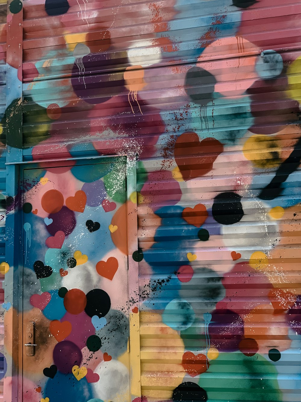 corações coloridos pintados em uma parede de metal