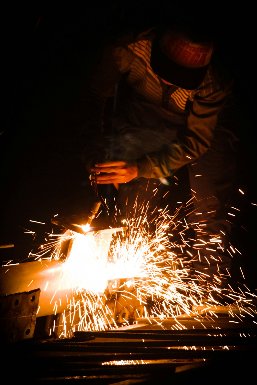 a person welding a piece of metal in the dark