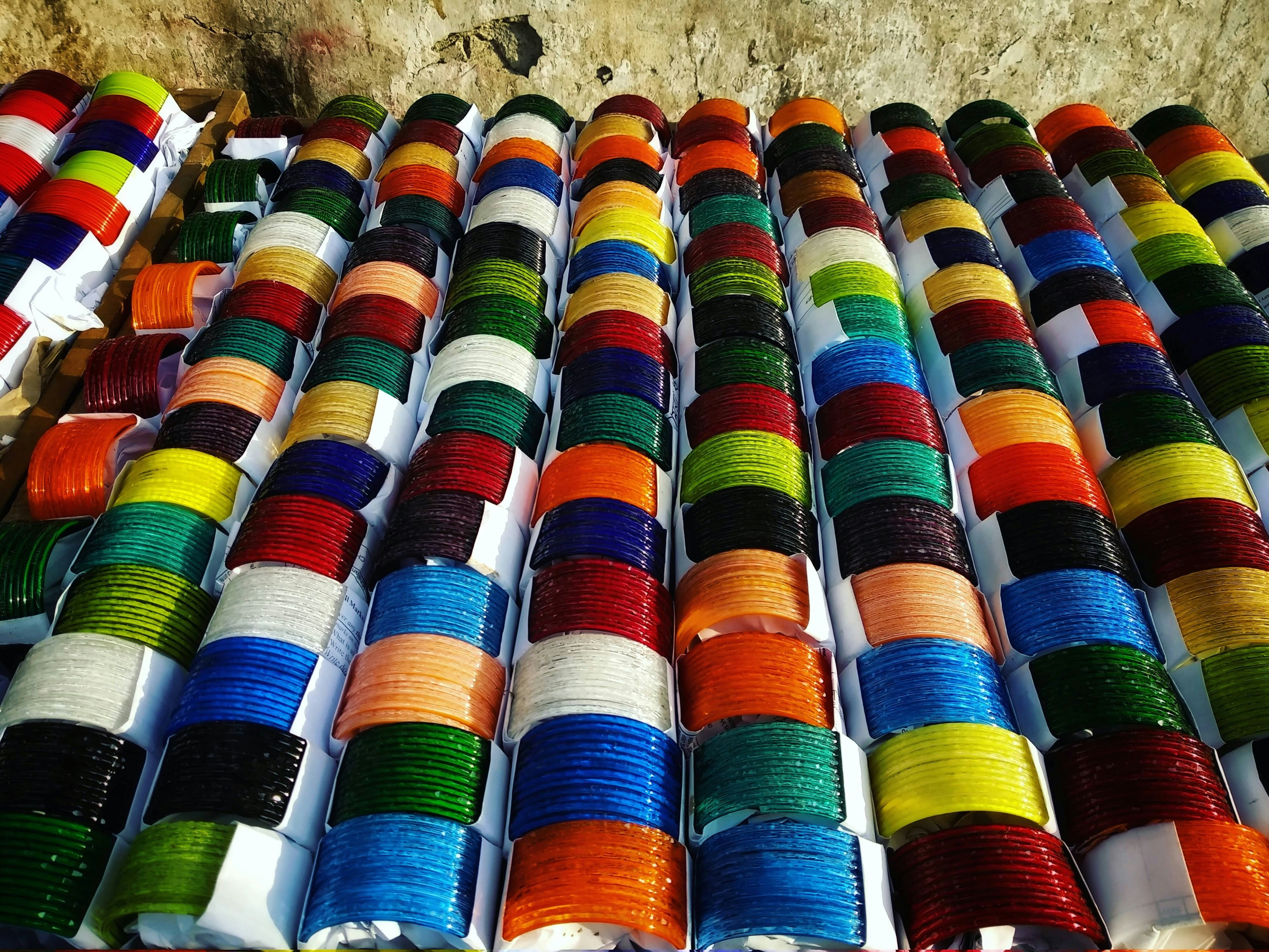 Vibrant colorful glass bangles arranged in a fan pattern on white surface