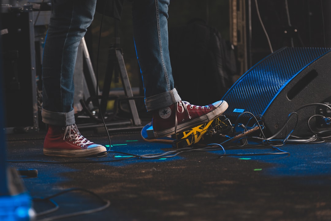 a person standing on top of a stage next to a microphone,