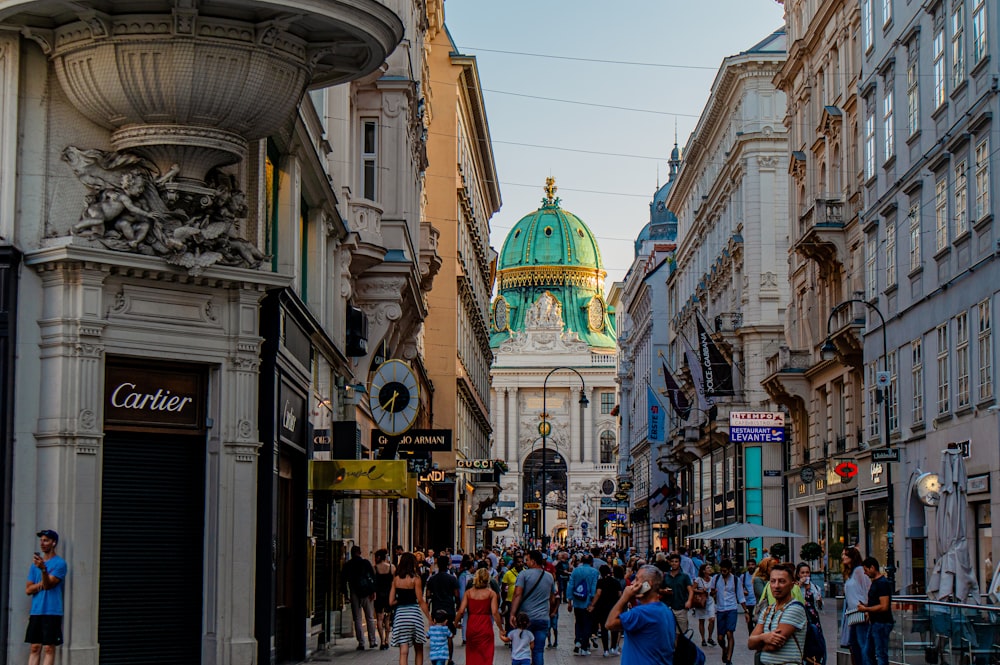 people walking in street between buildings