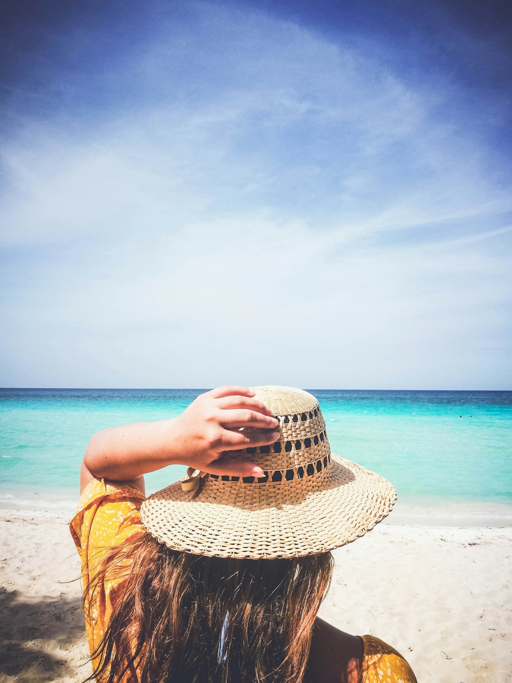 woman holding her hat