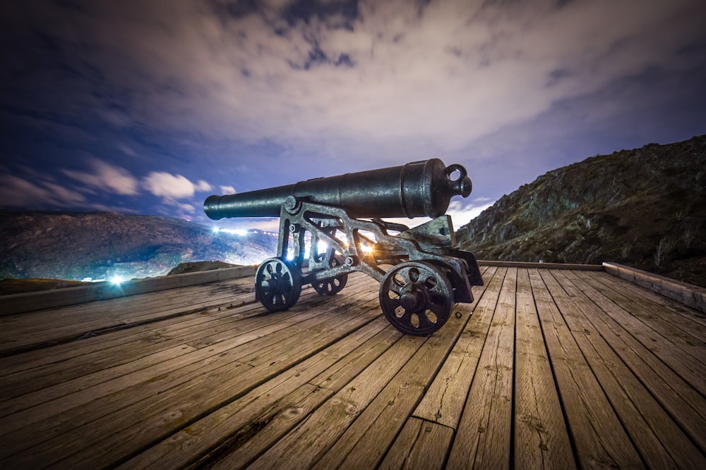 Cannone antico nero su piattaforma di legno marrone