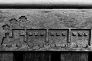 Rustic wooden train whistle resting on a textured aged paper with gold accents.