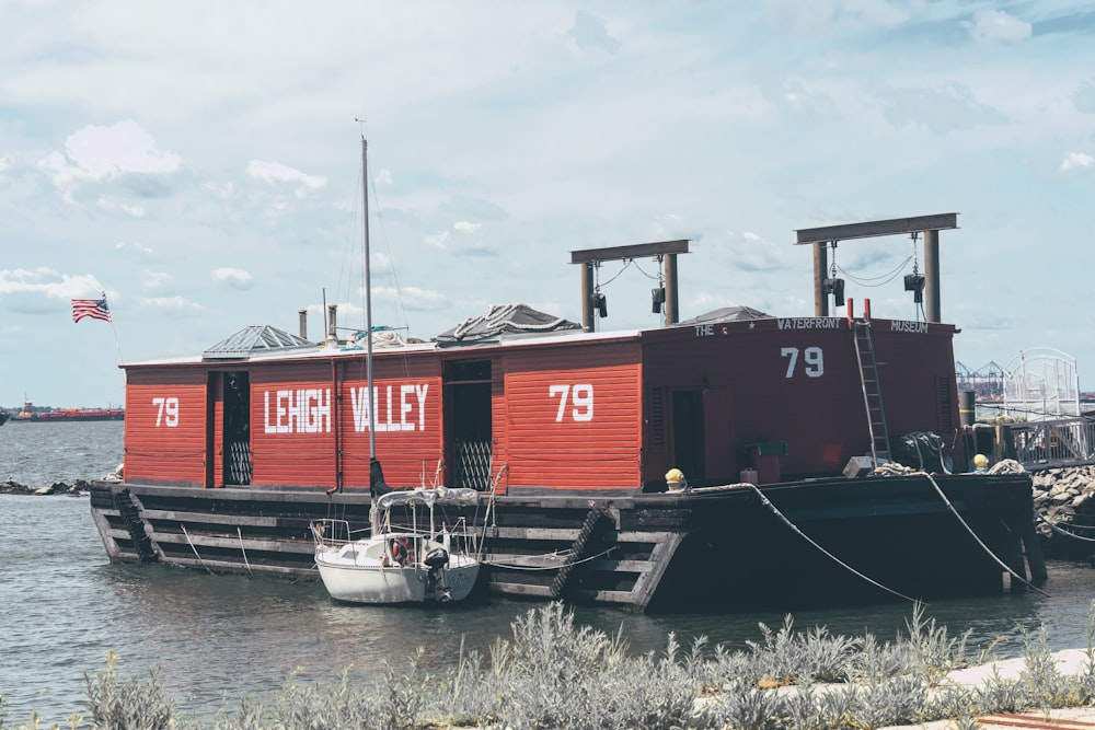 white powerboat moored beside red barge