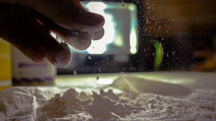 Close-up of fine black carbon anti moisture powder spilling from a container.