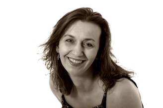 A warm, vintage photo of Lucila smiling surrounded by family and friends.