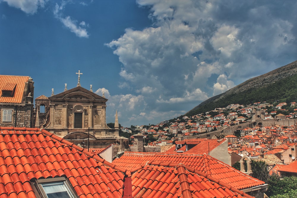 a red tiled roof with a church in the background