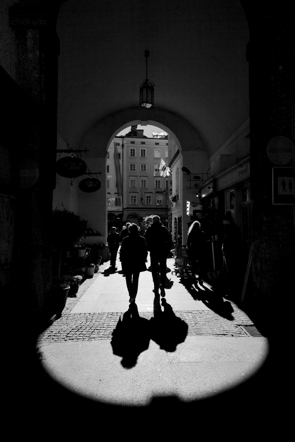 grayscale photo of people entering arc gate