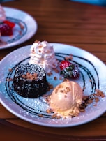 A dessert plate featuring a slice of chocolate cake with a scoop of vanilla ice cream and fresh berries.