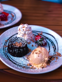 A dessert plate featuring a slice of chocolate cake with a scoop of vanilla ice cream and fresh berries.