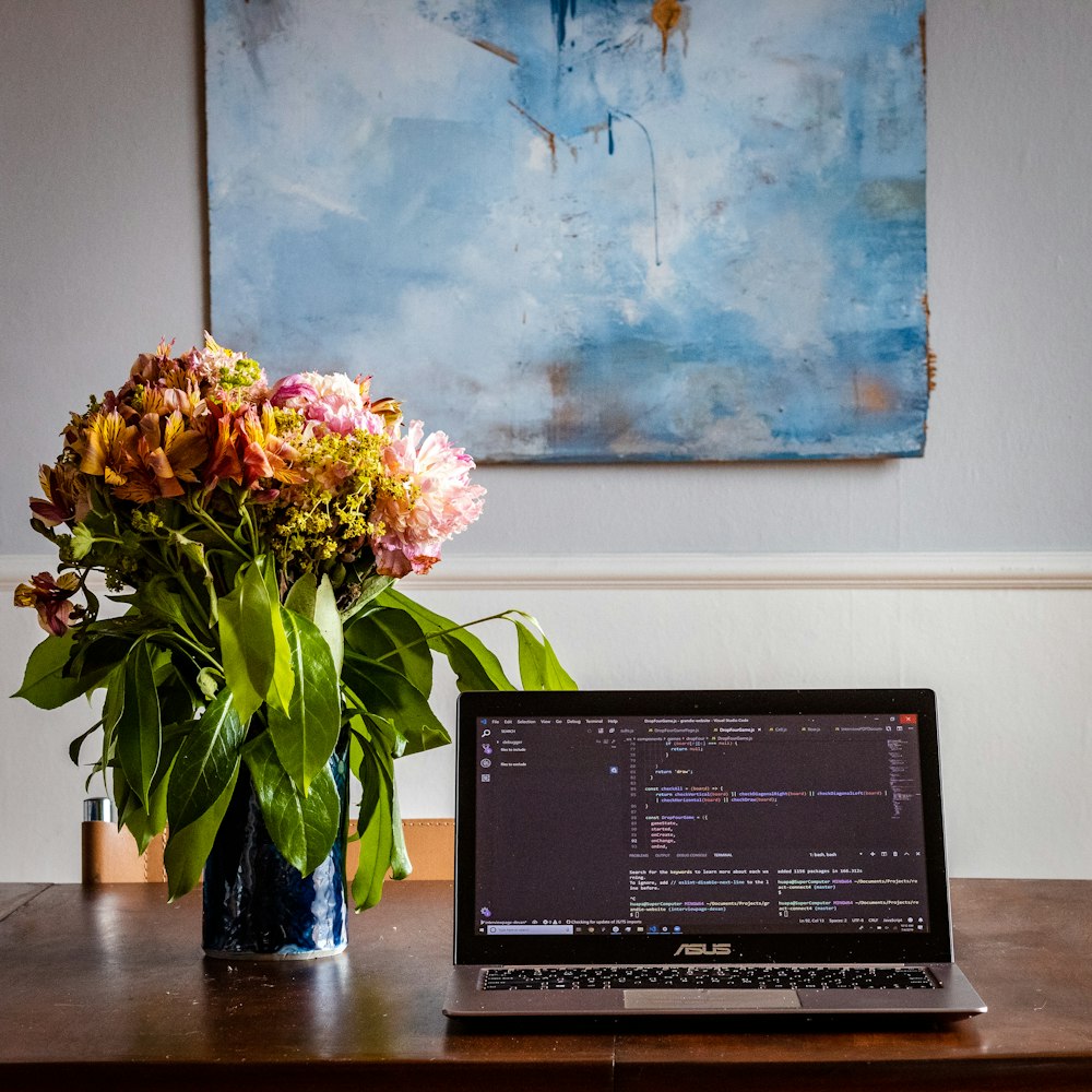 a laptop computer sitting on top of a wooden table