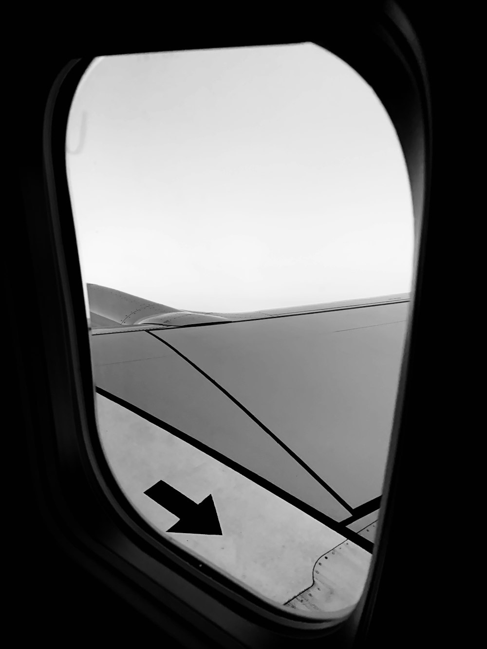 an airplane window with an arrow in the middle of it
