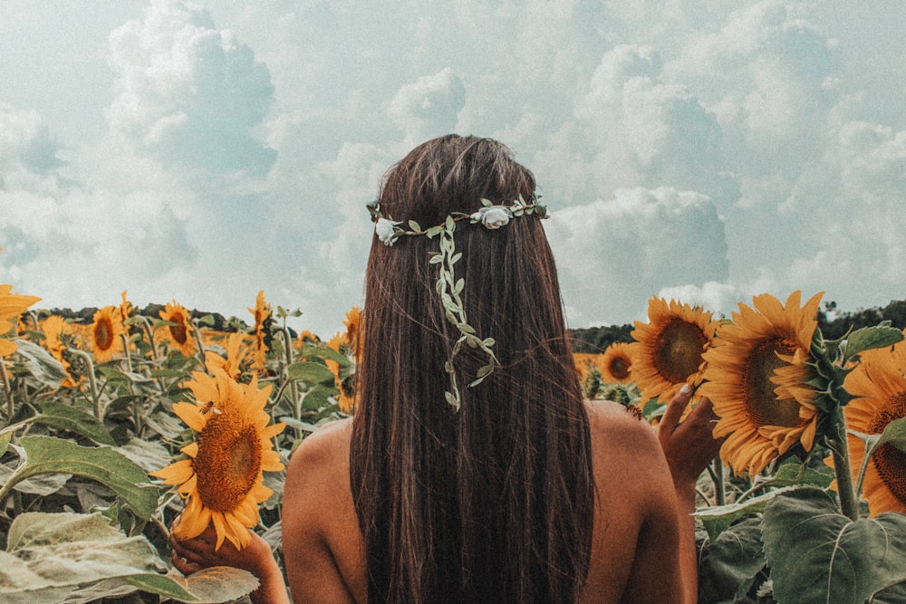 Frau steht in der Nähe von Sonnenblumenfeld