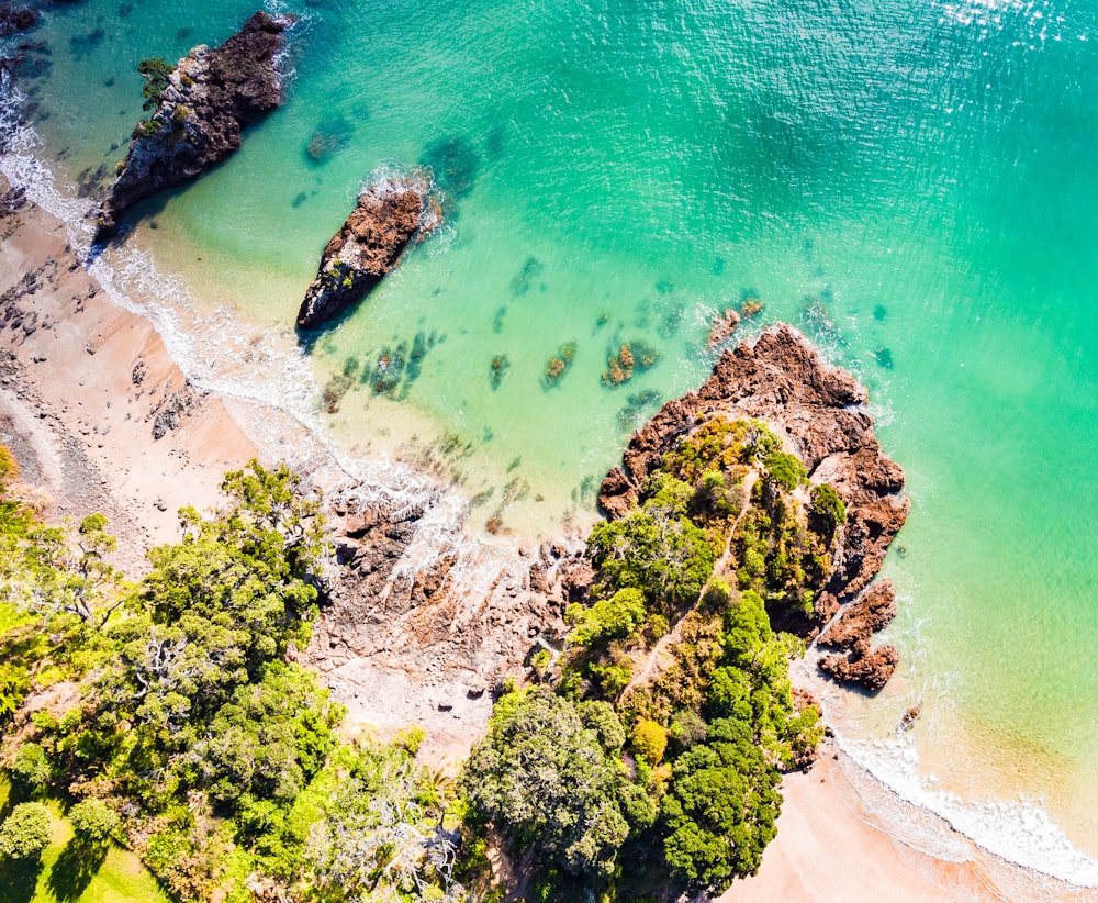 an aerial view of a beach with a rock outcropping