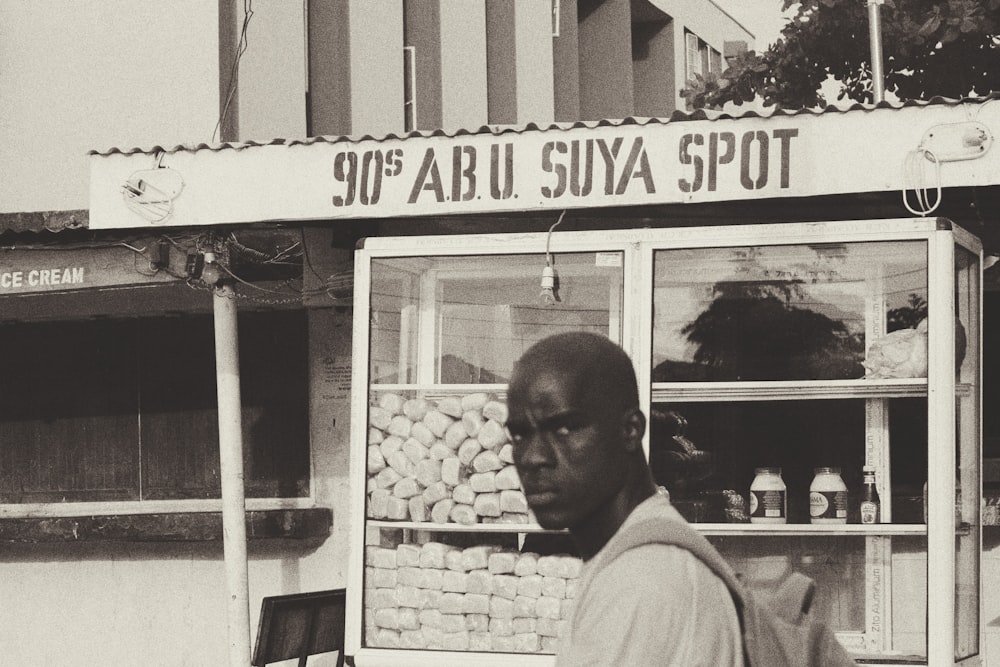 음식 마구간 근처에 서 있는 남자의 회색조 사진