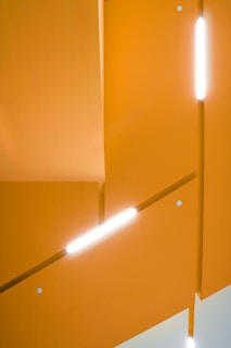Minimalist geometric shapes with glowing orange highlights on white background