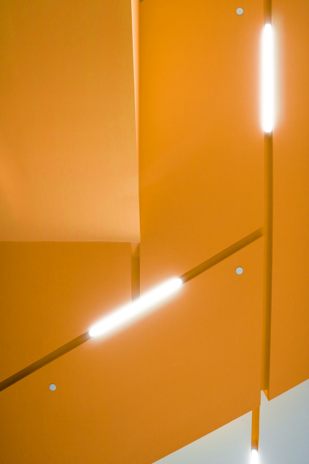 an orange wall with three lights on it