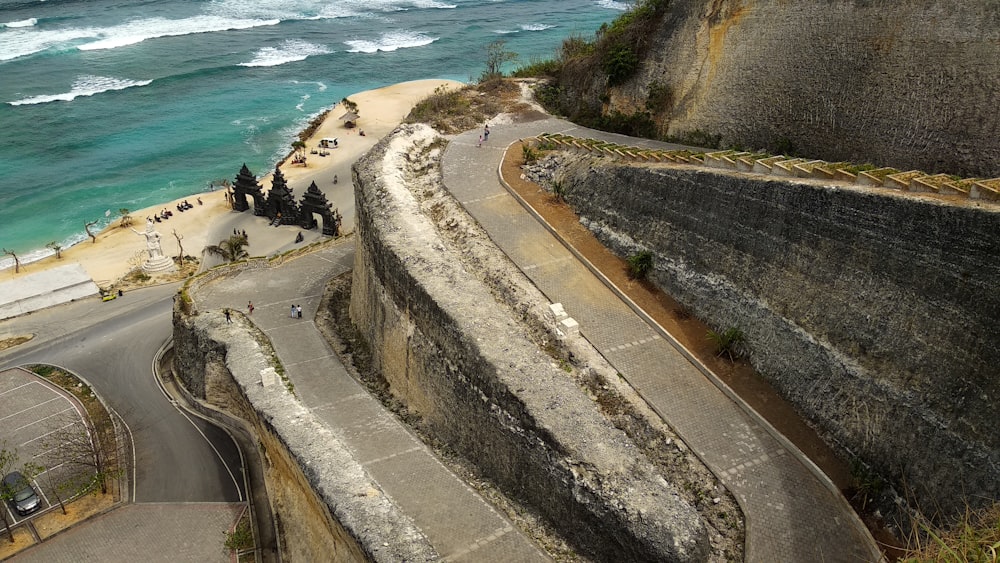 an aerial view of a winding road next to the ocean