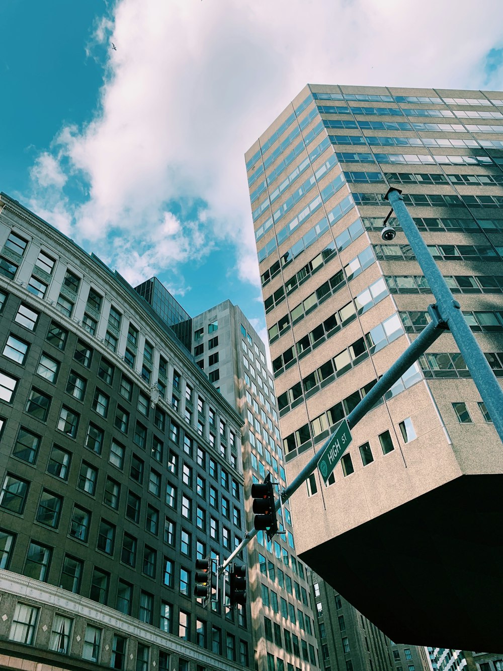 clear glass walled high-rise building under blue and white skies