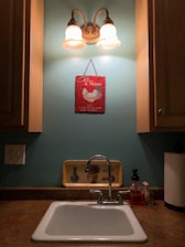 A friendly plumber fixing a kitchen sink under bright lighting.