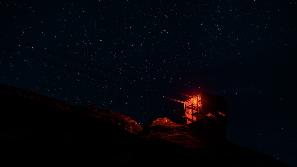 밤하늘 아래 언덕 꼭대기에 앉아 있는 작은 탑