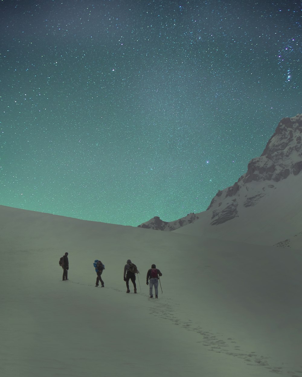 four people walking near mountain