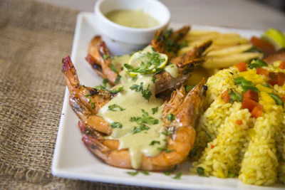 Prawns in a light sauce served with rice, representative of coastal Algarvian seafood cooking