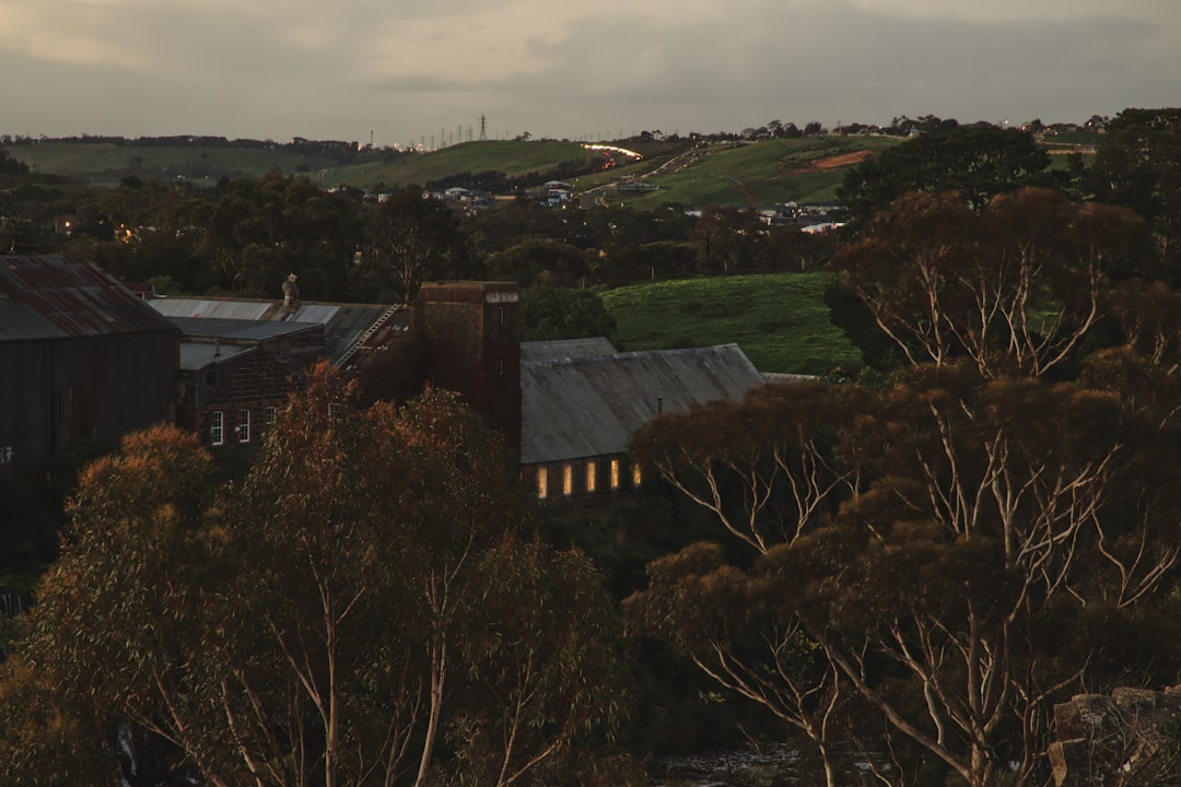 aerial view of building near trees under clouded sky