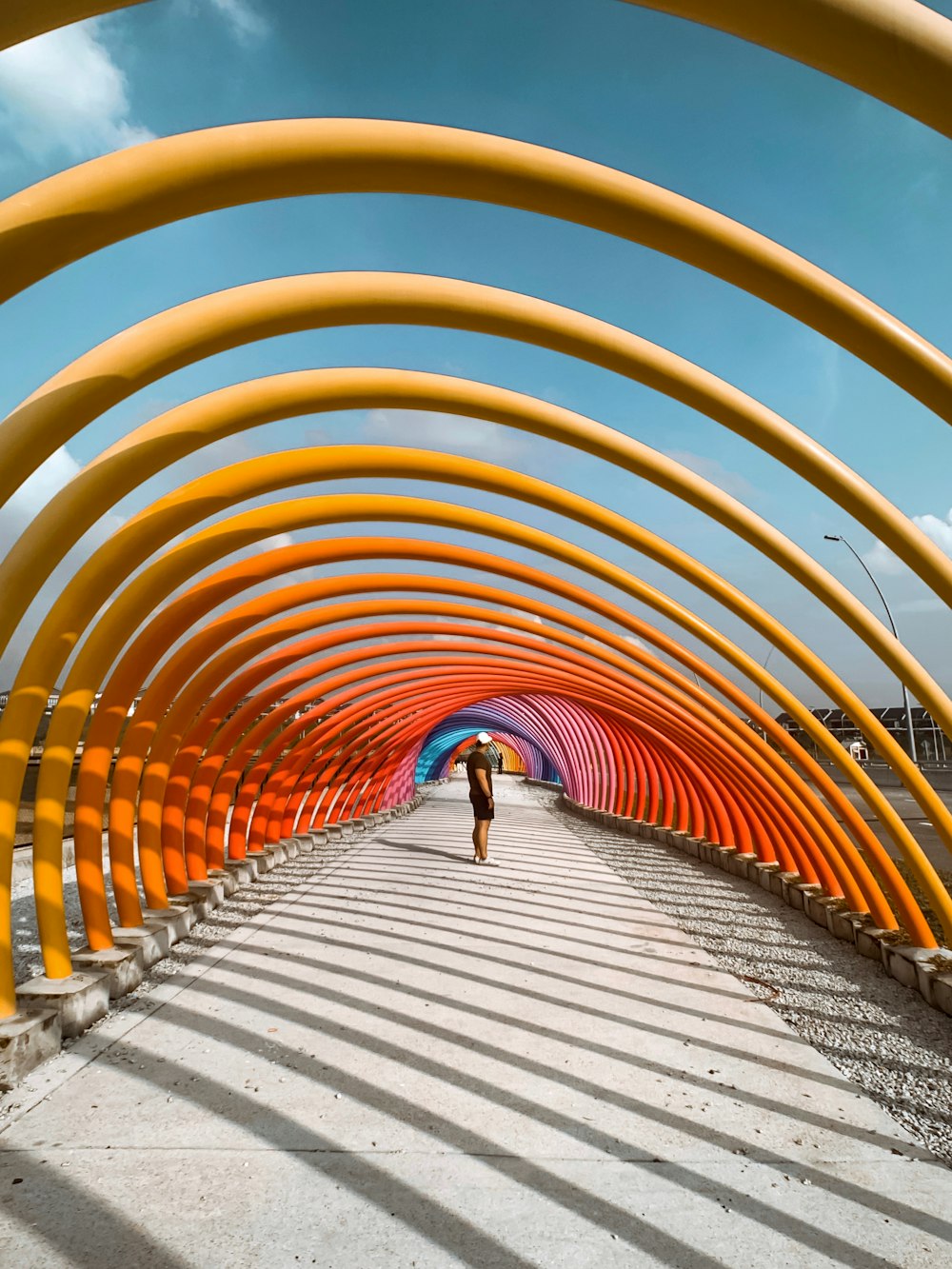 man standing under metal pipe arches