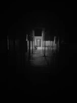 Dark, cinematic corridor with a high-end door slightly ajar, light spilling through.