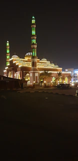 The majestic Masjid Nabawi illuminated at night, highlighting its green dome.